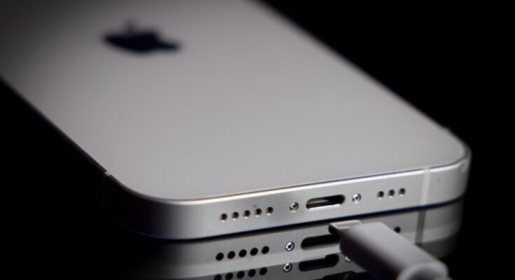 A Apple Lightning port charging cable is seen with with an iPhone.
