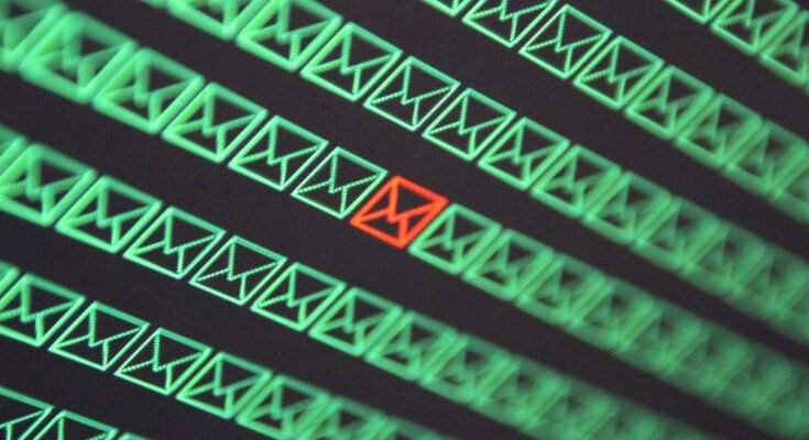 red email envelope in a sea of green email envelopes