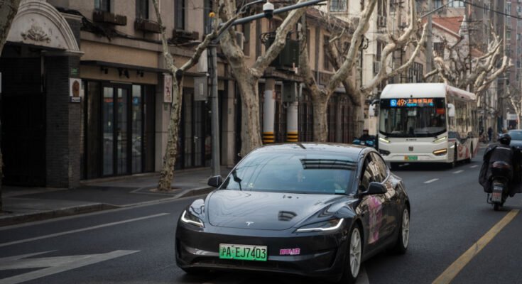 Tesla Model 3 vehicle drives on the street on February 27, 2025 in Shanghai, China.